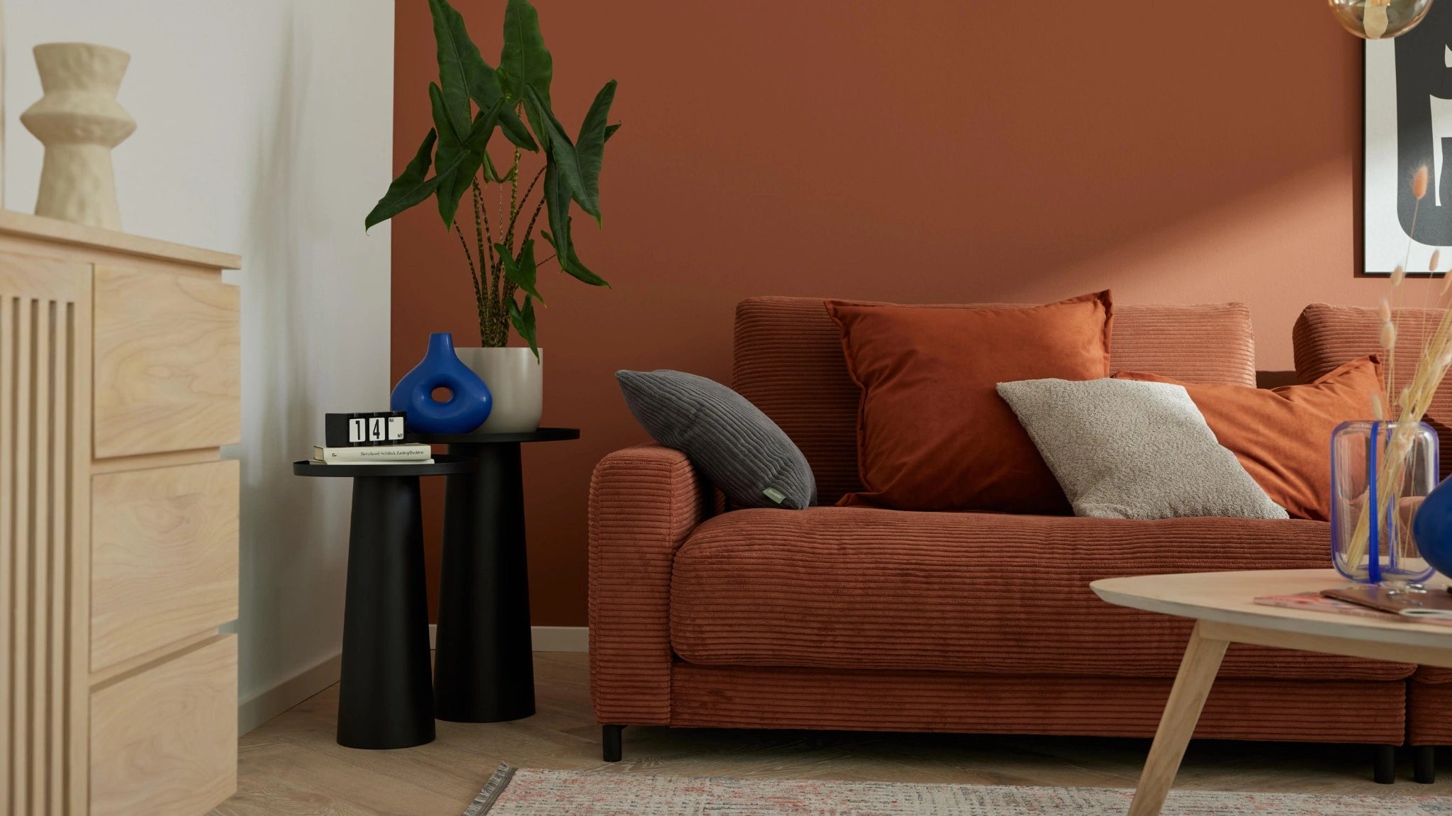 Modernes Wohnzimmer mit cognacfarbenem Sofa und dekorativen Kissen